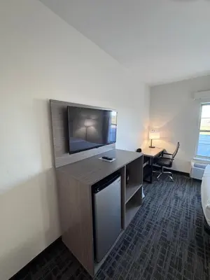 a hotel room with a flat screen tv and a desk at Ramada by Wyndham Sparta/At Speedway in Sparta