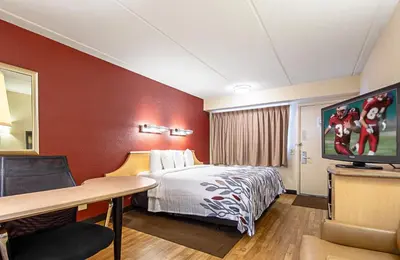 a hotel room with a bed and a flat screen tv at Red Roof Inn Charleston West - Hurricane, WV in Teays Valley Estates