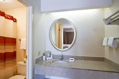 a bathroom with a sink and a mirror at Red Roof Inn Charleston West - Hurricane, WV in Teays Valley Estates