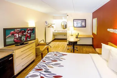 a hotel room with a bed and a flat screen tv at Red Roof Inn Charleston West - Hurricane, WV in Teays Valley Estates