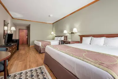 a hotel room with two beds and a flat screen tv at Super 8 by Wyndham Grayson in Grayson