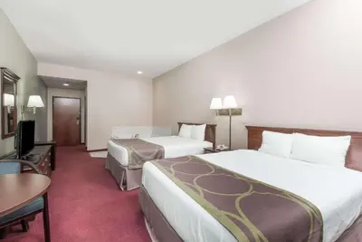 a hotel room with two beds and a table at Super 8 by Wyndham Grayson in Grayson