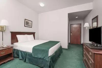 a hotel room with a bed and a flat screen tv at Super 8 by Wyndham Grayson in Grayson