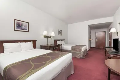 a hotel room with two beds and a desk at Super 8 by Wyndham Grayson in Grayson