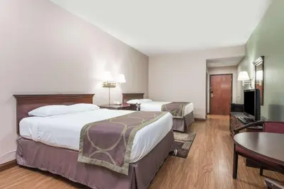 a hotel room with two beds and a table at Super 8 by Wyndham Grayson in Grayson