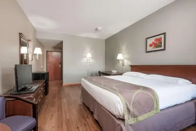 a hotel room with a bed and a flat screen tv at Super 8 by Wyndham Grayson in Grayson