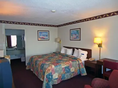 a hotel room with a bed and a chair at Motel 6-Troy, OH in Troy