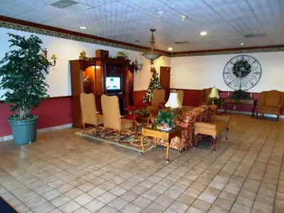a living room with a couch and chairs and a tv at Motel 6-Troy, OH in Troy