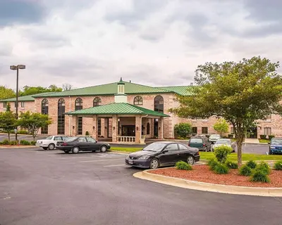 a large building with cars parked in a parking lot at Quality Inn & Suites Cincinnati I-275 in Springdale