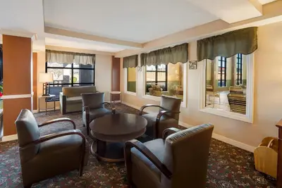 a hotel room with chairs and a table and a living room at Quality Inn & Suites Cincinnati I-275 in Springdale