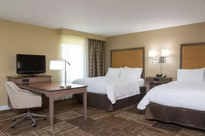 a hotel room with two beds and a desk and a television at Hampton Inn & Suites Fremont in Fremont