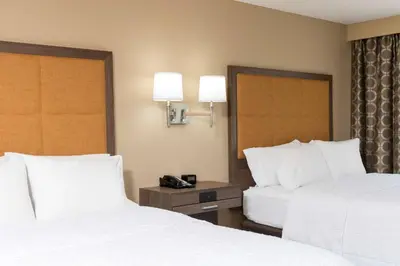 a hotel room with two beds and a telephone at Hampton Inn & Suites Fremont in Fremont