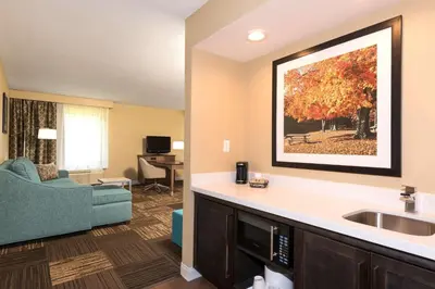 a hotel room with a sink and a living room at Hampton Inn & Suites Fremont in Fremont