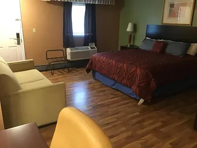 a bedroom with a bed and a couch and a chair at Bellevue Hotel and Suites in Bellevue