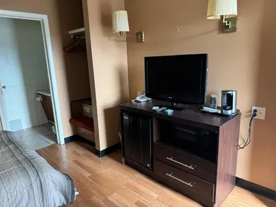 a living room with a flat screen tv on a dresser at Bellevue Hotel and Suites in Bellevue