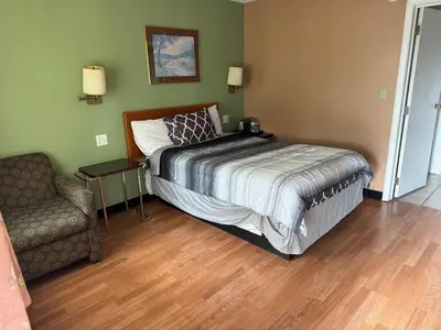 a bedroom with a bed and a couch and a chair at Bellevue Hotel and Suites in Bellevue