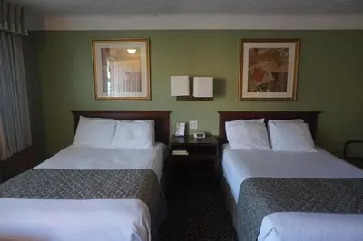 two beds in a hotel room with green walls at Bellevue Hotel and Suites in Bellevue