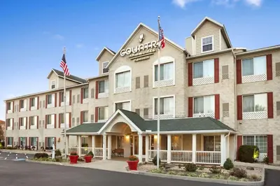 a hotel with two american flags in front of it at Country Inn & Suites by Radisson, Columbus Airport, OH in Columbus