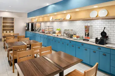 a restaurant with blue cabinets and wooden tables at Country Inn & Suites by Radisson, Columbus Airport, OH in Columbus