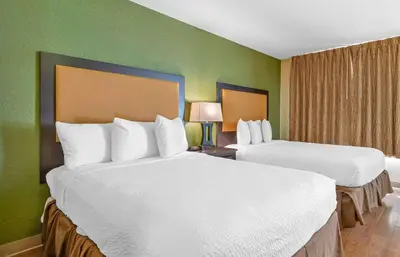 two beds in a hotel room with green walls at Extended Stay America Suites - Columbus - Tuttle in Dublin