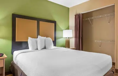 a large white bed in a room with green walls at Extended Stay America Suites - Pittsburgh - Airport in Imperial