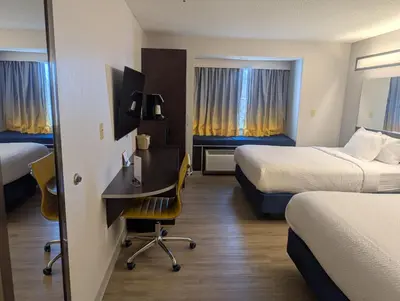 a hotel room with two beds and a desk in it at Microtel Inn & Suites by Wyndham Wheeling at The Highlands in Triadelphia