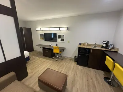 a hotel room with a desk and a bed at Microtel Inn & Suites by Wyndham Wheeling at The Highlands in Triadelphia
