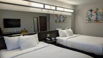 a hotel room with two beds and a mirror at Microtel Inn & Suites by Wyndham Wheeling at The Highlands in Triadelphia