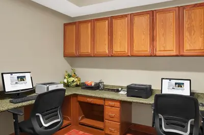an office with two computers on a desk with two chairs at Hampton Inn Athens in Athens