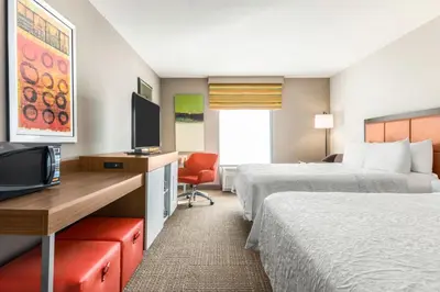 a hotel room with two beds and a flat screen tv at Hampton Inn Athens in Athens