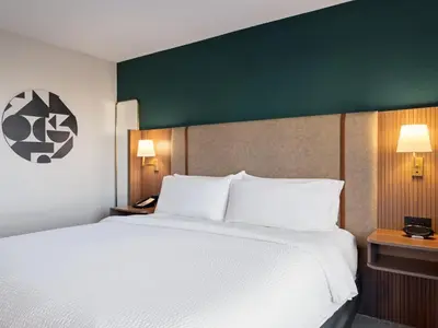 a bedroom with a large bed and a green wall at Holiday Inn Portsmouth Downtown by IHG in Portsmouth