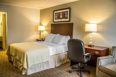 a hotel room with a bed and a desk and a chair at Quality Inn Cambridge in Cambridge