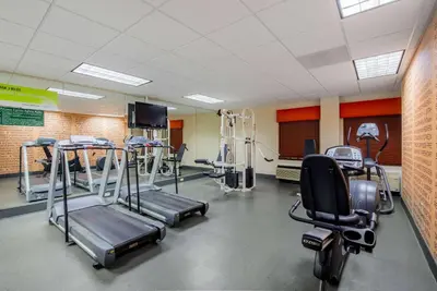 a gym with several tread machines in a room at La Quinta by Wyndham Elkview - Charleston NE in Elkview