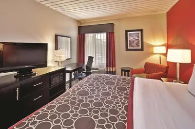 a hotel room with a bed and a flat screen tv at La Quinta by Wyndham Elkview - Charleston NE in Elkview