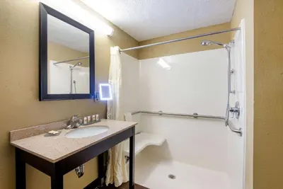 a bathroom with a sink and a shower with a mirror at La Quinta by Wyndham Elkview - Charleston NE in Elkview