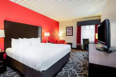 a hotel room with a bed and a flat screen tv at La Quinta by Wyndham Elkview - Charleston NE in Elkview