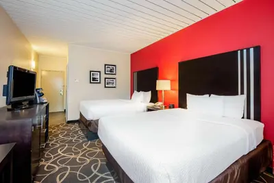 a hotel room with two beds and a flat screen tv at La Quinta by Wyndham Elkview - Charleston NE in Elkview
