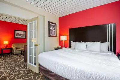 a bedroom with a large bed and a red wall at La Quinta by Wyndham Elkview - Charleston NE in Elkview