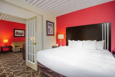 a bedroom with a large bed and a red wall at La Quinta by Wyndham Elkview - Charleston NE in Elkview