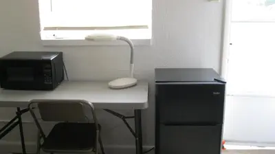 a desk with a microwave and a computer on it at The Ohio Motel in Bath