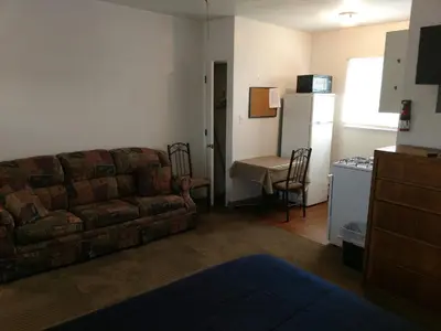 a living room with a couch and a refrigerator at The Ohio Motel in Bath
