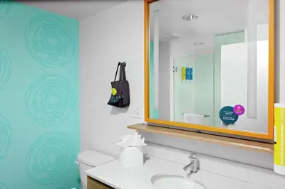 a bathroom with a sink and a mirror at Tru By Hilton Cleveland Midtown in Cleveland
