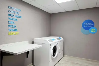 a laundry room with a washing machine in it at Tru By Hilton Cleveland Midtown in Cleveland