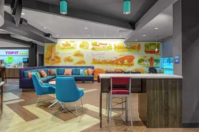 a lobby with a bar with chairs and a couch at Tru By Hilton Cleveland Midtown in Cleveland