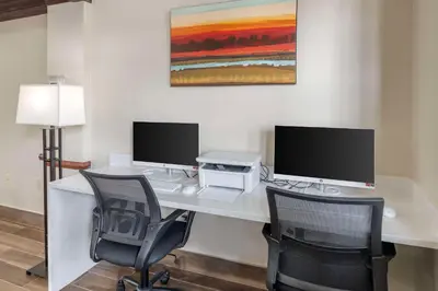 a desk with two computer monitors and two chairs at Best Western Mason Inn in Mason