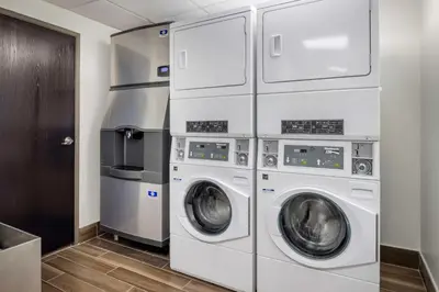 a laundry room with three washer and dryer at Best Western Mason Inn in Mason