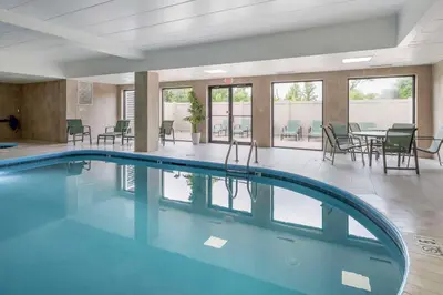 a pool in a room with chairs and tables at Best Western Mason Inn in Mason