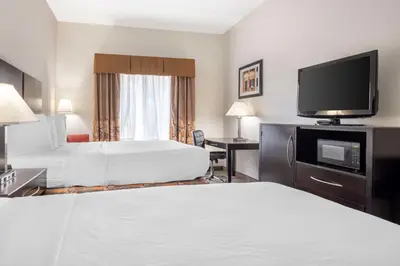 a hotel room with two beds and a flat screen tv at Best Western Mason Inn in Mason