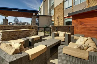 a patio with wicker chairs and couches on a building at Holiday Inn Express & Suites Wapakoneta by IHG in Wapakoneta