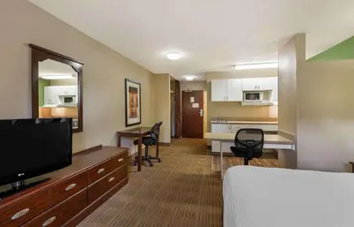 a hotel room with a bed and a flat screen tv at Extended Stay America Suites - Akron - Copley - East in Copley